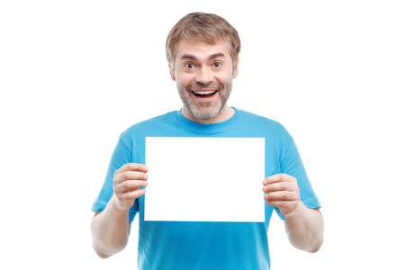 Be cheerful. Positive pleasant adult man holding paper and smiling while evincing joy.の写真素材