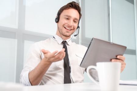 Upbeat communication. Vivacious smiling call center operator holding laptop and expressing...