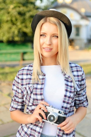 Young and beautiful. Elated pretty girl making holding camera and looking aside while feeling happy