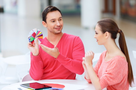 Lots of choice. Designer looks satisfied with all the variety of colour samples and presents them to his partner.の写真素材