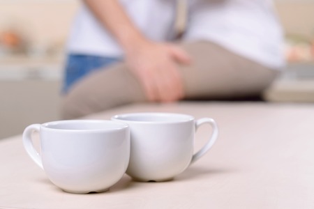 Enjoy yourself. Close up of cups with coffee standing on the table with young loving couple standing in the backgroundの写真素材