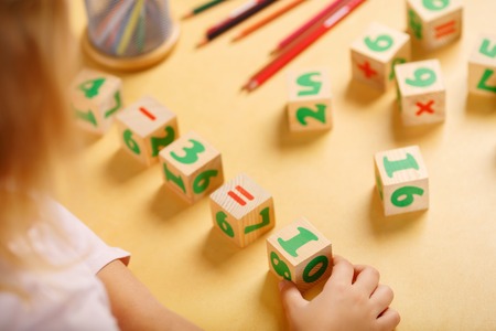 Little girl is playing with a set of unifix math cubes.の写真素材