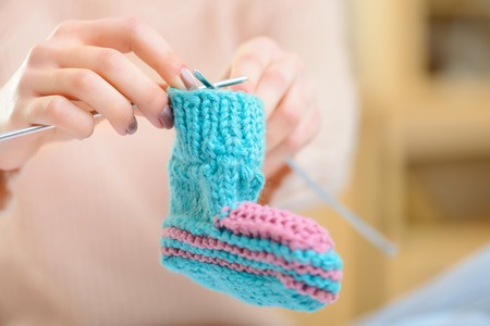 Cute knitwear. Close up of cute handmade baby knitwear in young girls hands.の写真素材
