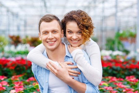 Happy couple. Lovely young couple is posing in the greenhouse.の写真素材