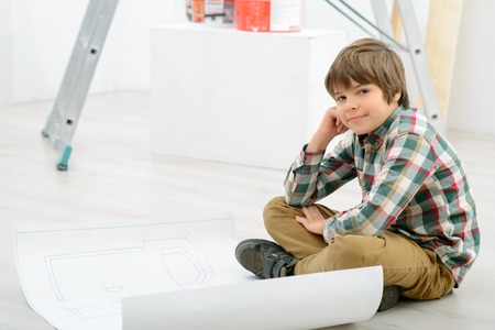 Lets smile, Positive cheerful little boy holding brus and painting sled while feeing vivaciousの写真素材