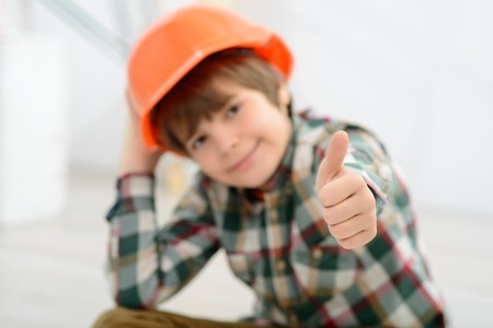 Everything is great. Selective focus of hand of little vivacious boy thumbing up and expressing happinessの写真素材