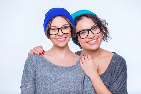 Sisters hug. Two young appealing sisters are smiling and hugging.の写真素材