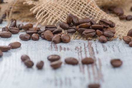 Feel the aroma. Close up of coffee beans lying on the brown fabric on the tableの写真素材