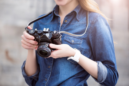 Camera usage. Cropped image of young woman using her camera while being outsideの写真素材