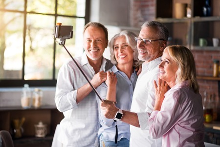 Happy time. Mature friends happily posing for a picture