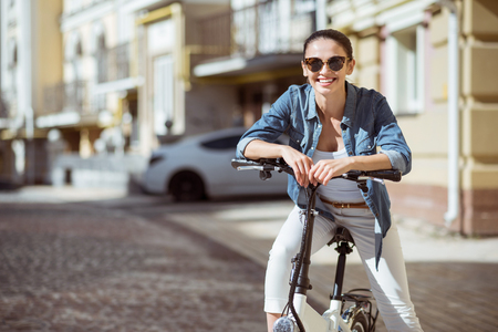 Express positivity. Positive content charming woman smiling and riding a bicycle while expressing joyの写真素材