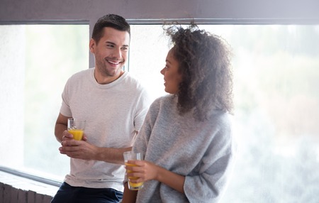 I love your smile. Young happy smiling couple drinking juice and laughing together while having their honeymoon.の写真素材