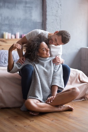 Love you so much. Lovely young happy couple sitting together in their bedroom and enjoying the...