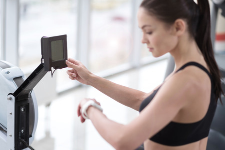 Keep an eye on it. Active young pretty girl controlling her weight and pulse using smart watch and...