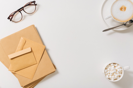 Morning post. Pile of paper envelopes lying on the white table near the eyeglassesの写真素材