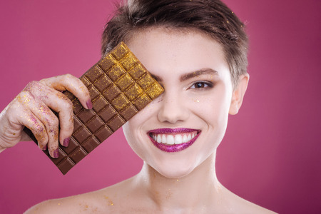Joyful smiling woman holding chocolate