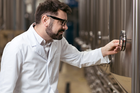 Concentrated man pressing a button on brewing mechanism