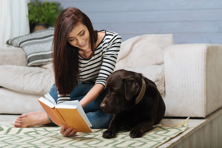 Caring sweet lady reading for her petの写真素材