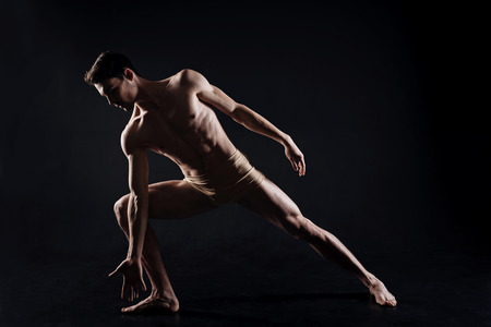 Inspired young athlete acting in the black colored studioの写真素材