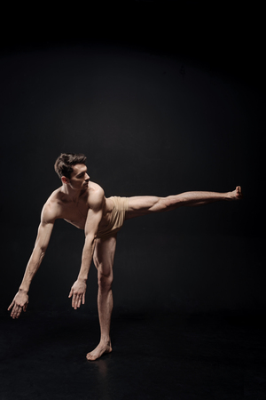 Young athlete dancing in the black colored studioの写真素材