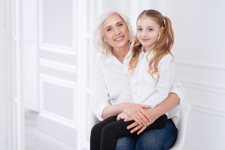 Positive little girl resting with her grandmotherの写真素材