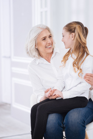 Cheerful girl and her grandmother resting togetherの写真素材
