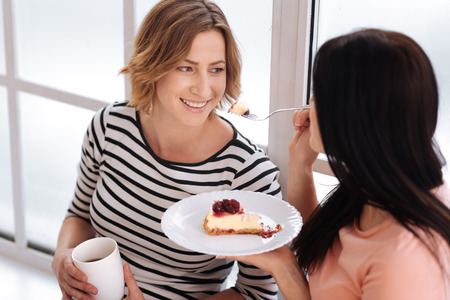 Beautiful friends sharing morning warmthの写真素材