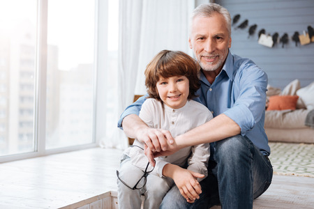 Positive aged man hugging his grandsonの写真素材