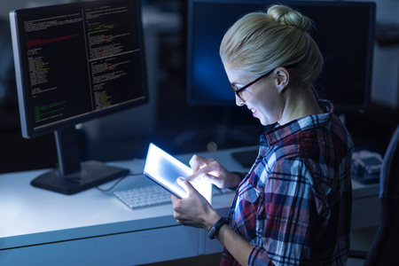 Attractive young IT girl decoding in the dark lighted room