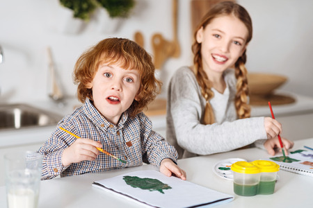 Excited talented siblings drawing some greensの写真素材