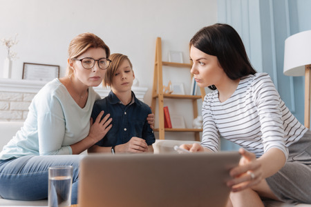 Attentive mother looking closely at laptopの写真素材