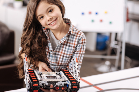 Smiling girl representing electronic toy at the robotics laboratoryの写真素材