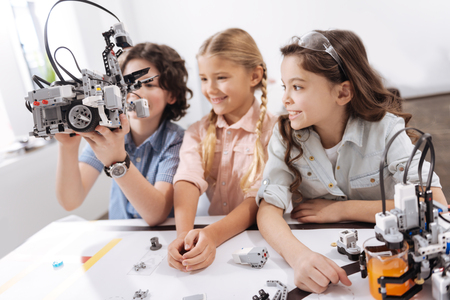 Amused kids exploring modern technologies at schoolの写真素材