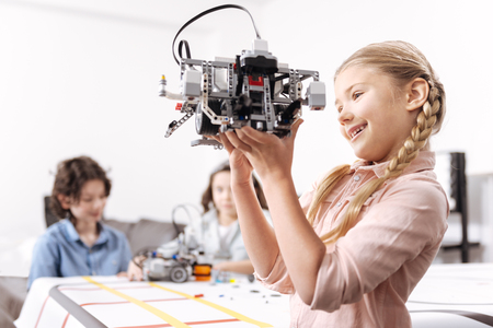 Energetic little girl playing with robot at schoolの写真素材