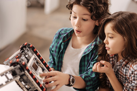Astonished children programming robot in the science studioの写真素材