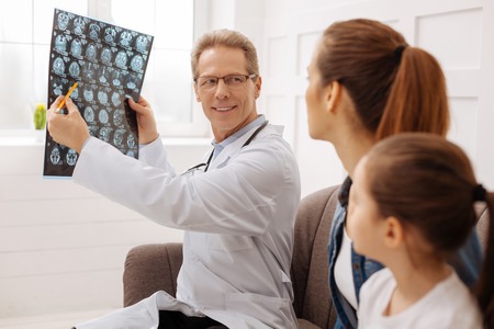 Charming doctor having some good news for his clientsの写真素材