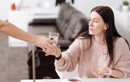 Attentive brunette holding handful of pillsの写真素材