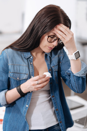 Attentive female person touching her foreheadの写真素材