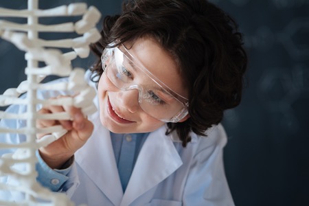 Cheerful pupil exploring genetic code at schoolの写真素材