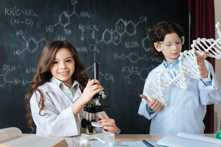 Positive little friends studying microbiology at school