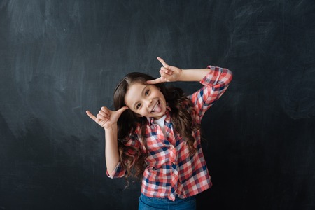 Playful little kid having fun in the black colored studioの写真素材