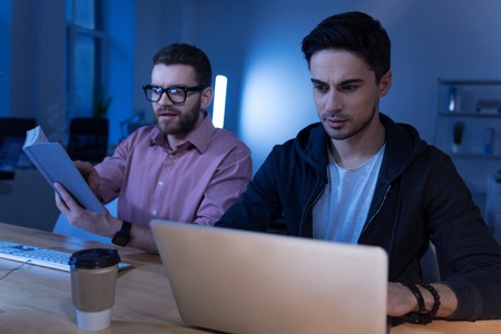 Serious brunette man working on the laptopの写真素材