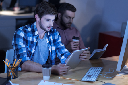 Serious thoughtful man reading newsの写真素材