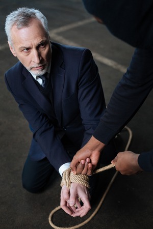 Sad cheerless man looking at his kidnapperの写真素材