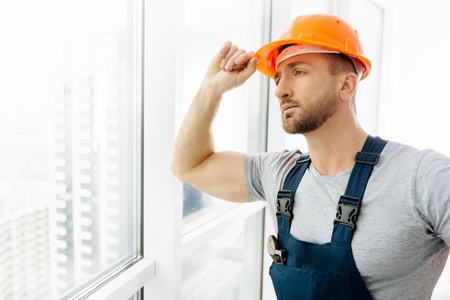 Waist up of construction engineer standing in the officeの写真素材