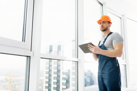 Low angle of professional construction engineer using tabletの写真素材