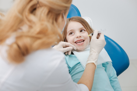 Enthusiastic adorable girl not afraid of her dentistの写真素材