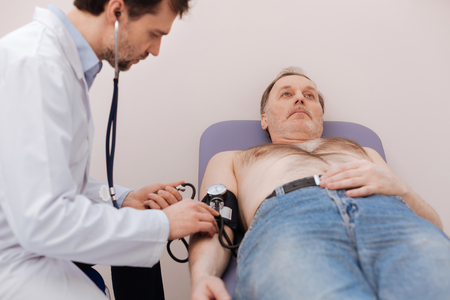 Trained medical worker checking patients pressureの写真素材