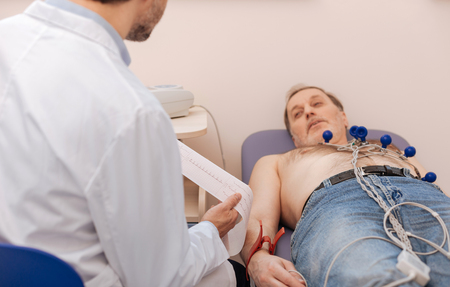 Prominent specialist reading the results of echocardiogramの写真素材