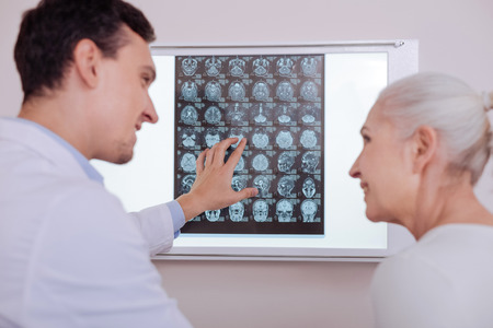 Delighted positive doctor looking at his patientの写真素材